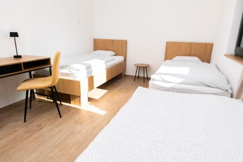 a room with two beds and a desk and a desk at Kozjanski dvor in Podčetrtek