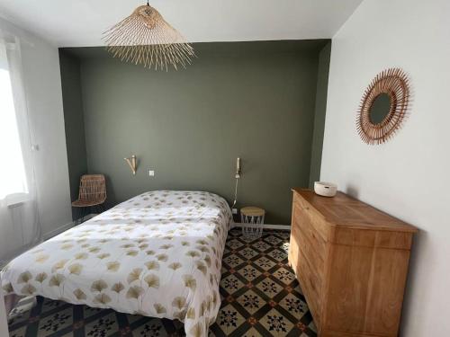 une chambre avec un lit, une commode et un miroir dans l'établissement La maison de Camille climatisation parking privé WIFI, à Carcassonne