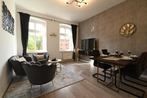 a living room with a dining room table and chairs at Dessaus Motto Appartements! Solo - Pärchen - Familien - Gruppen in Dessau