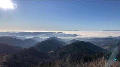 a view of a mountain range with the sun in the sky at Ferienwohnungen Golla-lang in Oberharmersbach