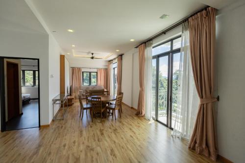 uma sala de jantar e sala de estar com mesa e cadeiras em Hills Aranda Nova Hotel em Cameron Highlands