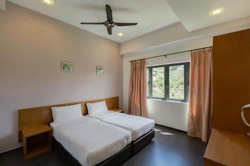 um quarto com uma cama e uma ventoinha de tecto em Hills Aranda Nova Hotel em Cameron Highlands
