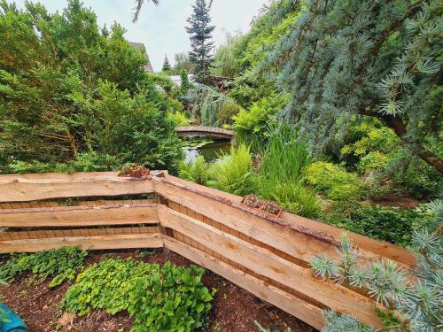a wooden bridge in the middle of a garden at Ferienwohnungen Golla-lang in Oberharmersbach