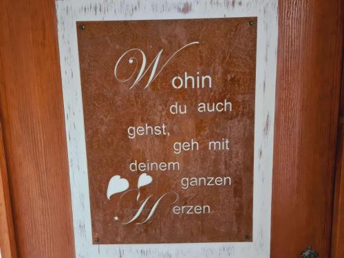 a sign on a wooden door with a menu on it at Ferienwohnungen Golla-lang in Oberharmersbach