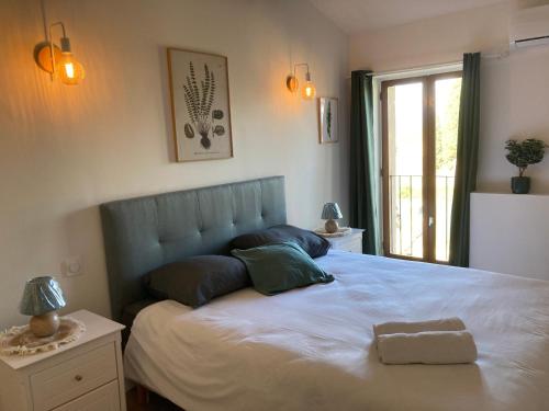1 dormitorio con 1 cama blanca grande y ventana en Maison indépendante, canal du Midi, Piscine, en Homps