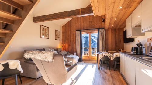 Il dispose d'une cuisine et d'un salon avec un canapé et des chaises. dans l'établissement LES BOUQUETINS 9 - sublime appt 4-6 pers, à Saint-Sorlin-dʼArves