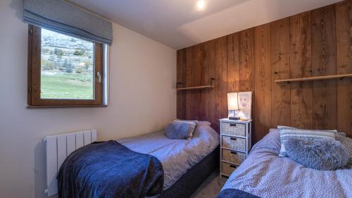 une chambre avec deux lits et une fenêtre dans l'établissement LES BOUQUETINS 9 - sublime appt 4-6 pers, à Saint-Sorlin-dʼArves
