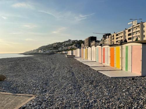 a beach with colorful buildings and the ocean at L’appart Duplex Bis in Le Havre