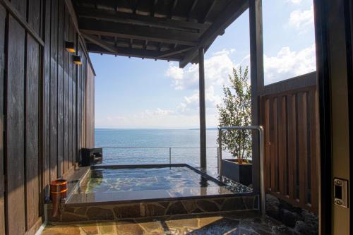 a view of the ocean from a house with a hot tub at La se ri Resort and Stay in Himi