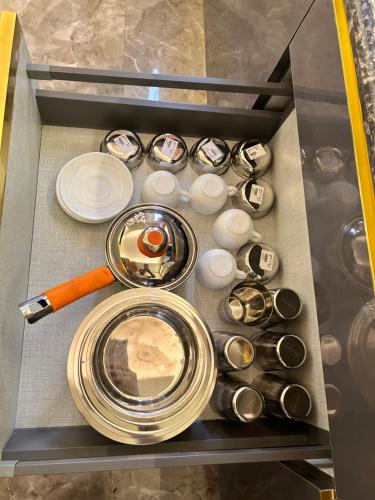a drawer filled with plates and utensils at Tripur Sundari Nilaya in Vrindāvan