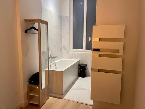 Un baño con bañera y ventana. en Appartement Haut de Gamme, Balnéo/ Balcon/ Garonne, en Toulouse