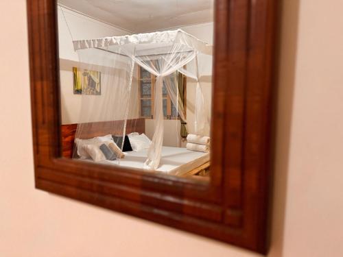 a mirror reflection of a bed in a room at Karibu Africa Home in Moshi