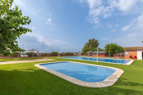 a large swimming pool on a green lawn at Camping tres estrellas Mediterráneo in Xilxes