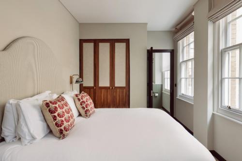 sypialnia z dużym białym łóżkiem z poduszkami w obiekcie Native Kings Wardrobe w Londynie