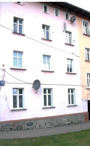 a white building with windows on the side of it at APARTAMENT NATALIA in Marciszów