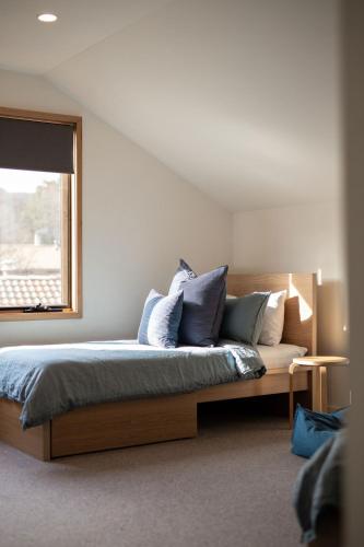 a bedroom with a bed with pillows and a window at The Wooden House in Bright