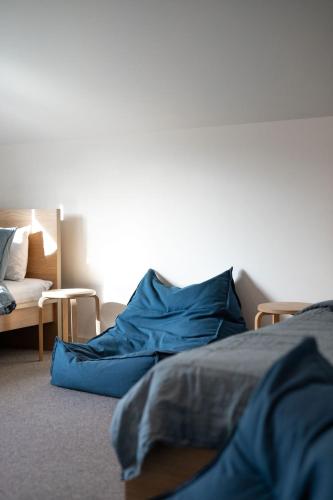 a bedroom with a bed with blue sheets and a couch at The Wooden House in Bright