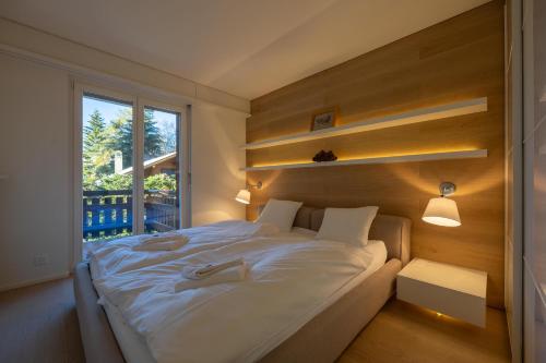 - une chambre avec un grand lit blanc et une fenêtre dans l'établissement Ecluses 7 - Nendaz centre & close to ski lift, à Nendaz