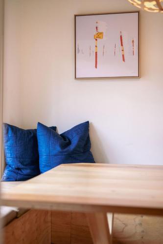 a table with blue pillows and a picture on the wall at The Wooden House in Bright