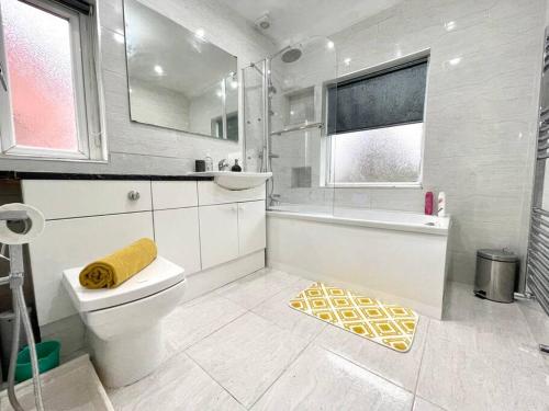 uma casa de banho branca com uma banheira e um WC em (S12) Bright 3 Bed Home With Free Parking Leeds em Killingbeck