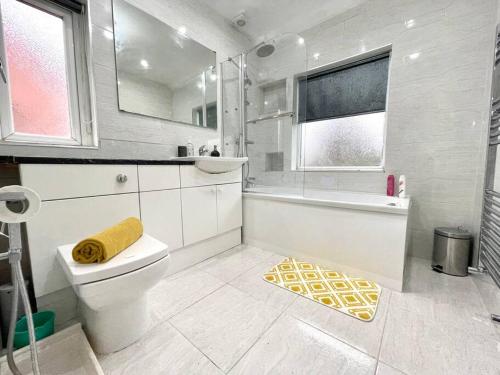 a white bathroom with a tub and a toilet at (S12) Bright 3 Bed Home With Free Parking Leeds in Killingbeck