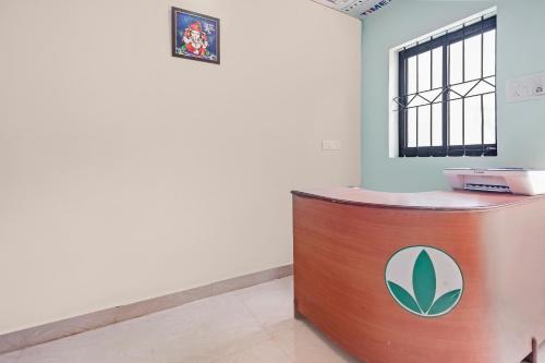 a reception desk in a room with a clock on the wall at OYO Hotel 49339 On The Rocks in Arambol