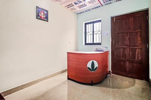 Pokój z drewnianymi drzwiami i czerwonym stołem w obiekcie OYO Hotel 49339 On The Rocks w mieście Arambol