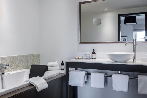 a bathroom with a tub and a sink and a mirror at Thon Partner Hotel Sorø in Sorø