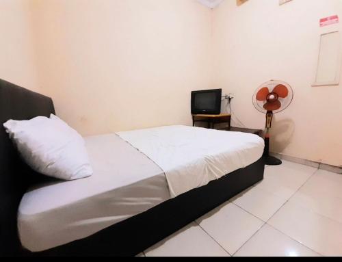 una camera con letto e TV di SPOT ON 93326 Pondok Anie Syariah a Pekanbaru