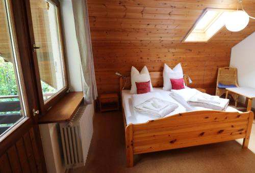 ein Schlafzimmer mit einem Bett in einem Holzzimmer in der Unterkunft Ferienwohnung Tannenblick - 3 Schlafzimmer, Feldberg-Falkau in Hinterfalkau