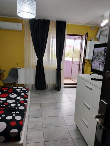 a room with a kitchen with a bed and a window at Studio 10 in Mamaia Sat/Năvodari