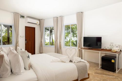 a white bedroom with a bed and a tv at The AVA Resort Koh Tao in Ko Tao