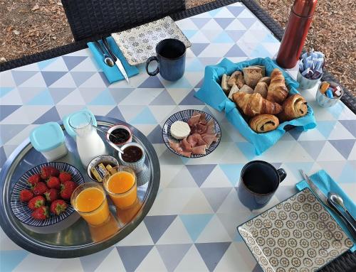 - une table avec un plateau de produits pour le petit-déjeuner et des boissons dans l'établissement Gîte Le Clos de la Canéda, à Sarlat-la-Canéda