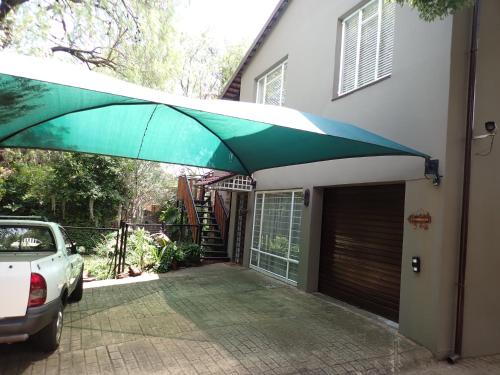 a green and white umbrella over a garage at Edwil's Place in Hartbeespoort