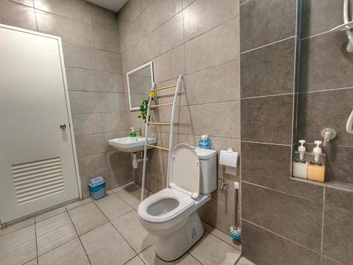 La salle de bains est pourvue de toilettes et d'un lavabo. dans l'établissement Let's Go Homestay, à Kuching