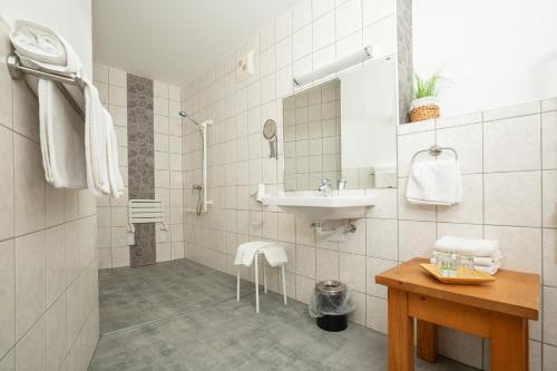 ein Bad mit einem Waschbecken, einer Dusche und einem Waschbecken in der Unterkunft Appartements Alpengarten in Mallnitz