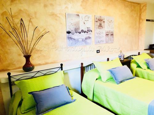 Pokój z 2 łóżkami z zielonymi i niebieskimi poduszkami w obiekcie Casita Bellavista with great views in Mozaga w mieście Mozaga