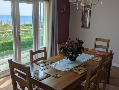 una mesa de comedor con un jarrón de flores. en Elmbank Accommodation, en Berwick-Upon-Tweed