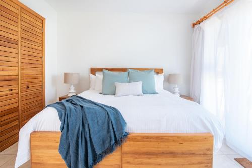a bedroom with a large white bed with blue pillows at The Phoenix Resort in San Pedro