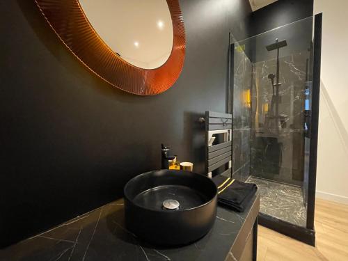 La salle de bains est pourvue d'un lavabo noir et d'une douche. dans l'établissement Merveilleux T2 de Standing à 90m de la Garonne, à Toulouse