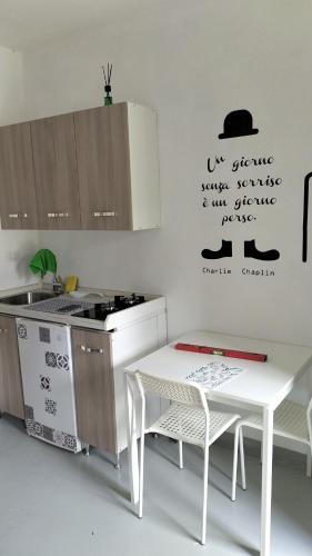 uma cozinha com um lavatório, um fogão e uma mesa em Casa Alma monolocale per 2 persone em Porto Ercole