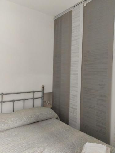 a bedroom with a bed and a sliding door at Casa Alma monolocale per 2 persone in Porto Ercole