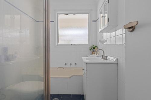 a bathroom with a tub and a sink and a shower at Bonus Studio Space in Budgewoi