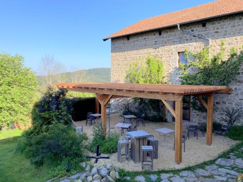 a wooden pergola in front of a building at Le Jardin des 4M in Saint-Régis-du-Coin