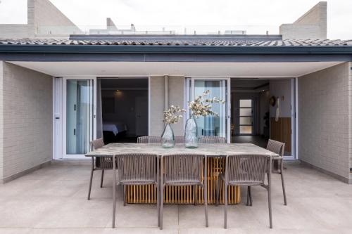 a dining table and chairs on a patio at The Blonde Bungalow Ballito in Ballito