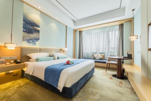 a bedroom with a large bed and a desk at Century Runhua Hotel in Jinan