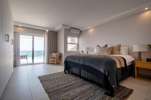 um quarto com uma cama e vista para o oceano em The Blonde Bungalow Ballito em Ballito