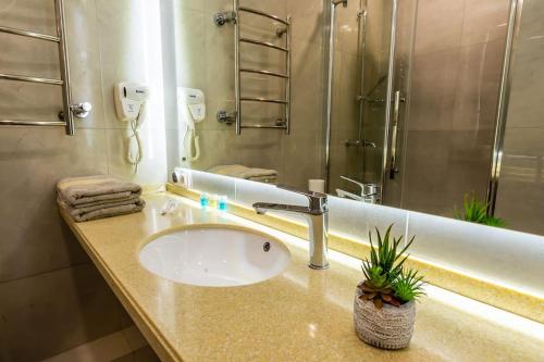een badkamer met een wastafel en een douche bij Apartments in the Golden square 141 in Alma-Ata
