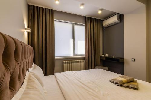 ein Hotelzimmer mit einem Bett und einem Fenster in der Unterkunft Apartments in the Golden square 141 in Almaty