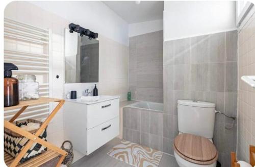 a bathroom with a toilet and a sink and a tub at Maison cosy Paris Orly jardin privée in Vitry-sur-Seine